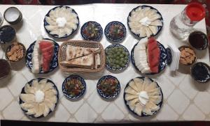 a table topped with blue and white plates of food at "YOQUT HOUSE" guest house in the centre of ancient city in Khiva