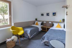 a bedroom with two beds and a yellow chair at The Architect's Villa in Lévktron