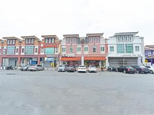 a row of buildings with cars parked in a parking lot at OYO 582 Hotel Walk Inn in Malacca