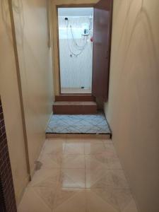 a bathroom with a shower and a tiled floor at CiTY Roomstay Budget Midtown Kuala Terengganu 2queen beds in Kuala Terengganu