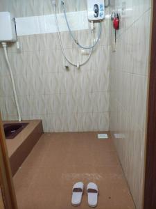 a pair of slippers are on the floor of a bathroom at CiTY Roomstay Budget Midtown Kuala Terengganu 2queen beds in Kuala Terengganu