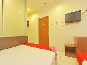 Schlafzimmer mit einem Bett und einem Flachbild-TV in der Unterkunft OYO 582 Hotel Walk Inn in Malakka