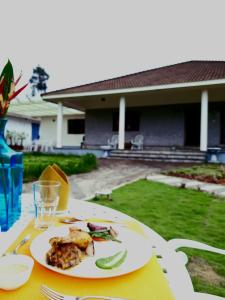 un tavolo con un piatto di cibo sopra di Villa Wodeyarmutt Tropical luxury living a Sringeri