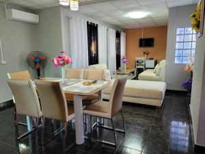 sala de estar con mesa, sillas y sofá en Residence Casablanca en Ambatoloaka