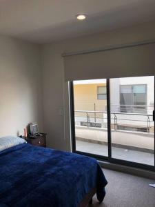 een slaapkamer met een blauw bed en een groot raam bij Beautiful 3BR townhouse with on-premises parking in Calimaya de Díaz González