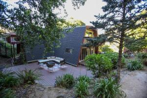 a house with a courtyard with a couch and a table at Amazing Cabin-Style House with Decks, Hot Tub & Sun - Permit 2022-STR-2 in Brisbane