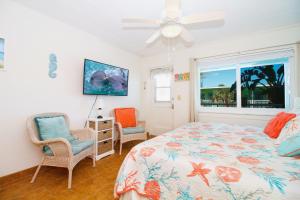 - une chambre avec un lit, deux chaises et une fenêtre dans l'établissement Tropic Terrace #31 - Beachfront Rental condo, à St. Pete Beach