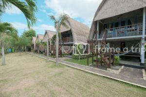 a row of houses with palm trees in front of them at Dream Beach Kubu & SPA by ABM in Nusa Lembongan