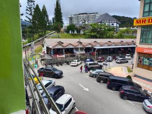 a parking lot with cars parked in front of a store at CH TRAVELLERS INN in Tanah Rata