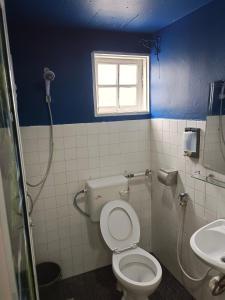 a bathroom with a toilet and a sink at CH TRAVELLERS INN in Tanah Rata