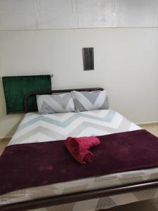 a bed with a red towel on top of it at CiTY Roomstay Budget Middle Kuala Terengganu 1queen bed in Kuala Terengganu