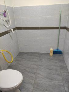 a bathroom with a toilet and a mop at CiTY Roomstay Budget Middle Kuala Terengganu 1queen bed in Kuala Terengganu