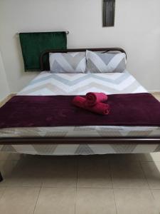 a bed with two red towels laying on it at CiTY Roomstay Budget Middle Kuala Terengganu 1queen bed in Kuala Terengganu