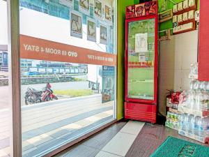a store front with a red door and a soda machine at OYO 89840 69 Room 4 Stay in Sibu