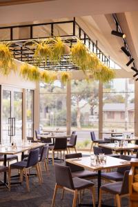 a restaurant with tables and chairs and a large window at Torquay Hotel/Motel in Torquay