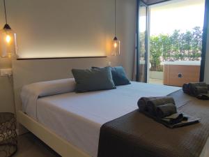 een slaapkamer met een groot bed en een groot raam bij Live Home Rooms in Villasimius