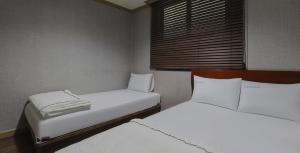 um quarto com duas camas e uma janela em Queen Motel Andong em Andong