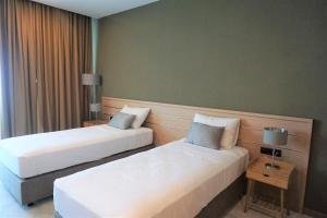 two beds in a hotel room with two tables at Mandrati Loft in Sarpi