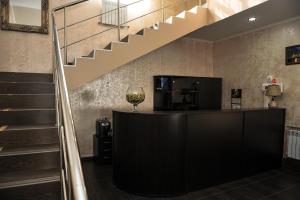 a lobby with a staircase and a counter with a wine glass at Hotel Svetofor in Lgov