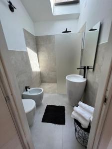 a white bathroom with a sink and a toilet at B-Guest House in Oristano