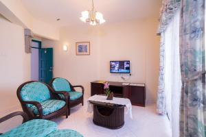a waiting room with chairs and a table at HIG Homestay Apartment in Kuah