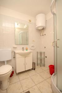 a bathroom with a toilet and a sink and a mirror at Apartments by the sea Valun, Cres - 8081 in Valun