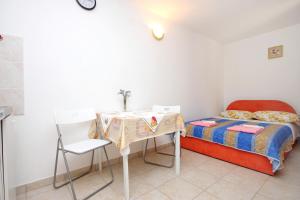 a small bedroom with a table and a bed at Apartments by the sea Valun, Cres - 8081 in Valun