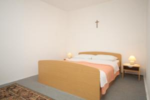 a bedroom with a bed with a wooden headboard at Apartment Verunic 8104a in Veli Rat