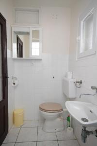 a bathroom with a toilet and a sink and a mirror at Apartment Verunic 8104a in Veli Rat