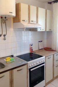 a kitchen with white cabinets and a stove top oven at Apartment Verunic 8104a in Veli Rat