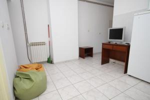 an empty room with a desk and a television at Apartment Mali Losinj 8090a in Mali Lošinj