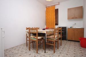 a kitchen with a table and chairs in a room at Apartments by the sea Zaglav, Dugi otok - 8134 in Sali