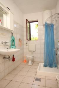 a bathroom with a sink and a toilet and a window at Apartments by the sea Zaglav, Dugi otok - 8134 in Sali