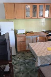 a kitchen with a white refrigerator and a table with a table at Apartment Savar 8079c in Brbinj