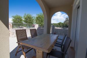a wooden table and chairs on a patio at Apartment Punta kriza 8082b in Nerezine