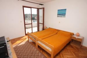 ein Schlafzimmer mit einem Bett mit orangefarbenem Laken in der Unterkunft Rooms by the sea Luka, Dugi otok - 8132 in Žman