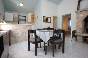 eine Küche und ein Esszimmer mit Tisch und Stühlen in der Unterkunft Secluded fisherman's cottage Cove Magrovica - Telascica, Dugi otok - 8142 in Sali