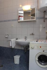 a bathroom with a sink and a washing machine at Apartment Mali Losinj 8090c in Mali Lošinj
