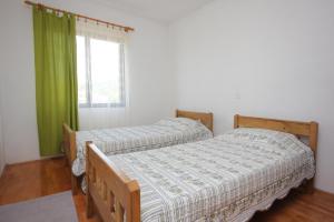 two twin beds in a room with a window at Apartments by the sea Sali, Dugi otok - 8121 in Sali