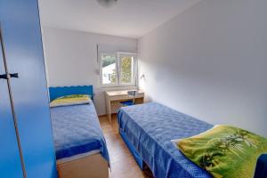 ein kleines Schlafzimmer mit 2 Betten und einem Schreibtisch in der Unterkunft Apartments by the sea Savar, Dugi otok - 8128 in Brbinj