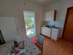 a small kitchen with a table and a counter top at Secluded fisherman's cottage Krknata, Dugi otok - 8150 in Zaglav