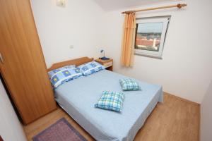 ein Schlafzimmer mit einem Bett mit blauen Kissen und einem Spiegel in der Unterkunft Apartments with WiFi Ilovik, Losinj - 8078 in Ilovik