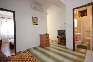 un salon avec une télévision et une chambre dans l'établissement Apartment Savar 8079a, à Brbinj