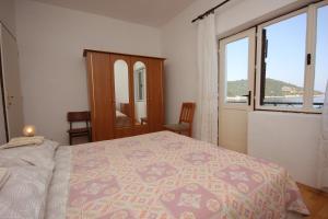 Brbinj的住宿－Apartment Savar 8079a，一间卧室设有一张床和一个大窗户