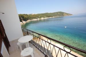 a balcony with a table and chairs and the ocean at Apartment Savar 8079a in Brbinj