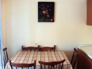 einen Tisch und Stühle in einer Küche mit einem Gemälde an der Wand in der Unterkunft Apartments by the sea Savar, Dugi otok - 8080 in Brbinj
