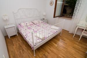 a white bed in a room with a wooden floor at Apartments by the sea Mali Losinj (Losinj) - 8093 in Mali Lošinj