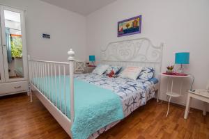a bedroom with a white bed with a blue comforter at Apartment Mali Losinj 8093b in Mali Lošinj