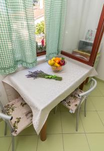 a table with a bowl of fruit and vegetables on it at Apartment Mali Losinj 8093b in Mali Lošinj