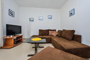 a living room with a couch and a tv at Holiday house with a parking space Veli Rat, Dugi otok - 8096 in Veli Rat